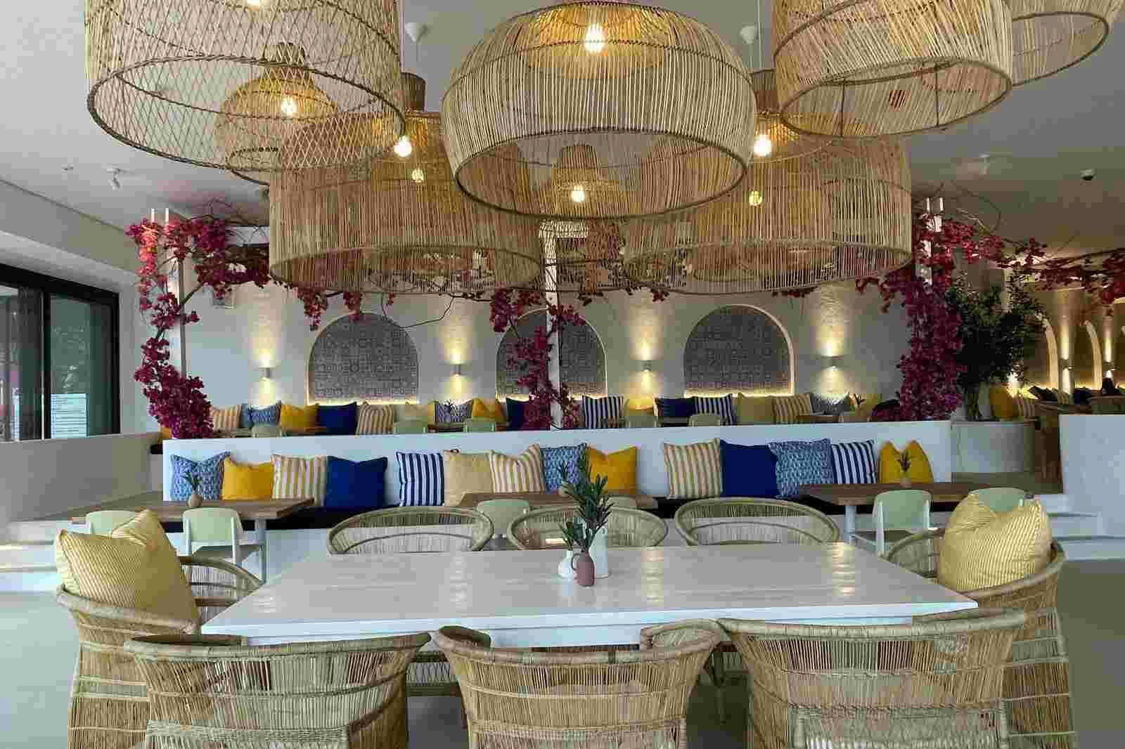 Restaurant interior with rattan pendant lights and colourful cushions