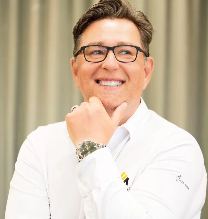 Smiling professional in white branded shirt and glasses
