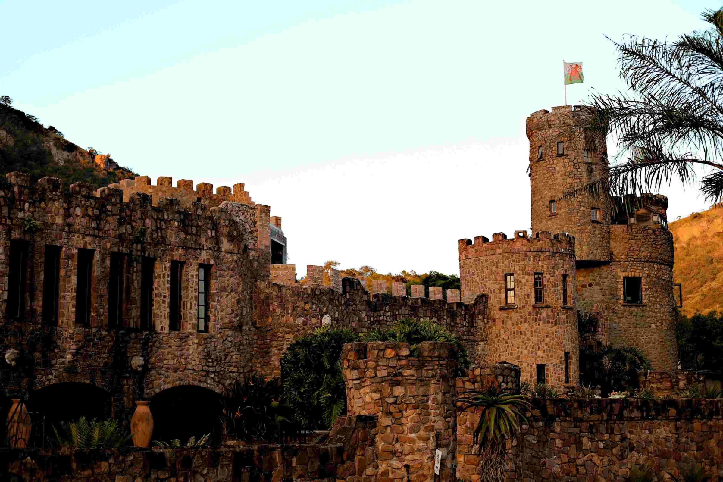 Stone castle with turrets and battlements against a hillside